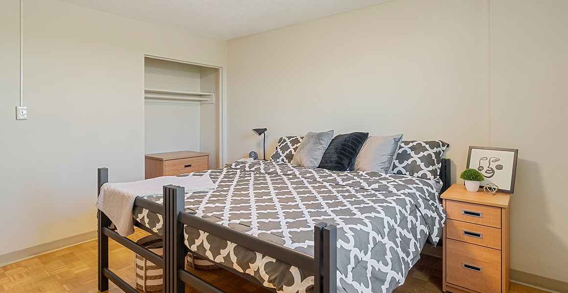 Bedroom showing bed, side table and closet