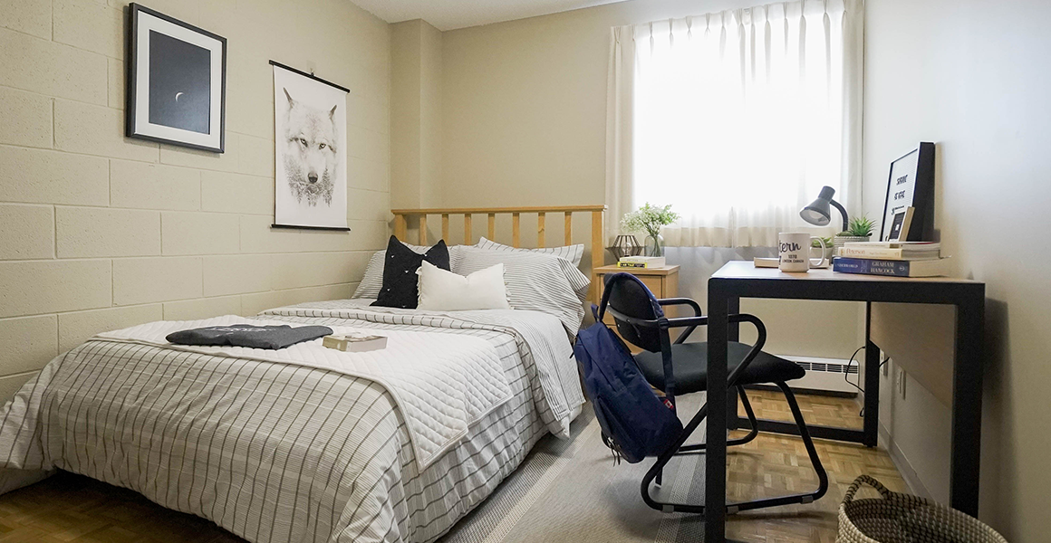 Bedroom showing bed, desk and window