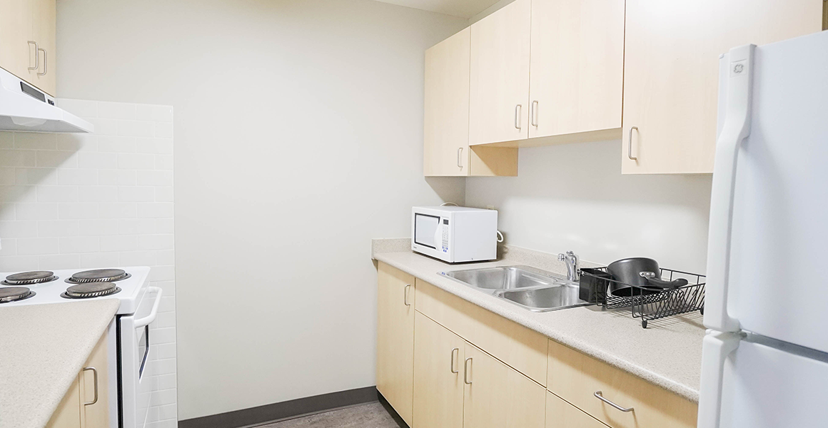 Kitchen showing cabinets, sink and fridge