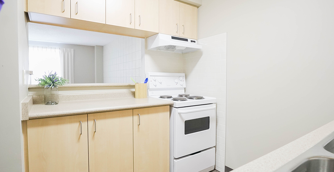 Kitchen showing oven, cabinets and mirror