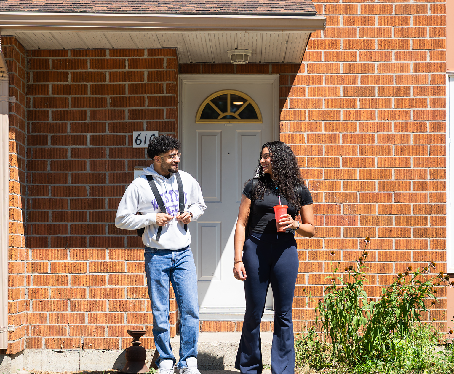 Two students standing out front of their building