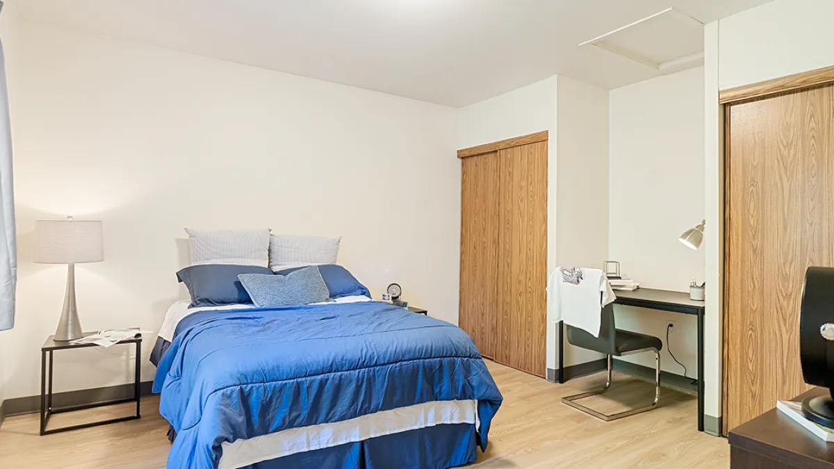 Bedroom showing bed, desk and two closets