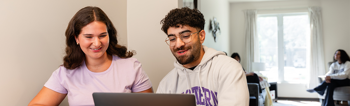 Two tenants sitting at the kitchen table looking at laptop